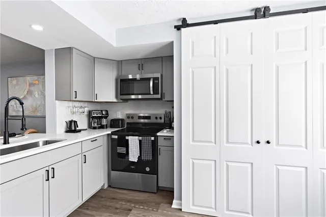 a kitchen with white cabinets and appliances