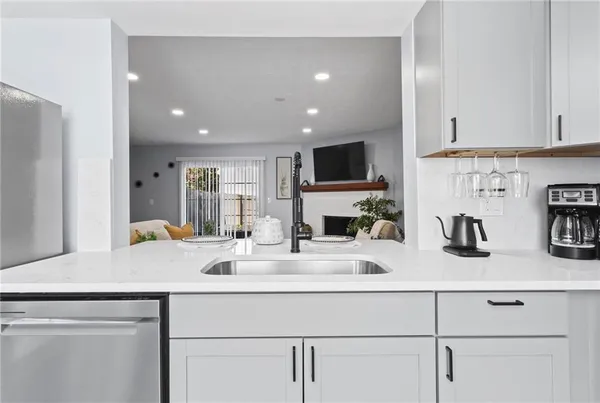 a kitchen with sink a microwave a stove and cabinets