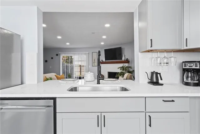 a kitchen with sink a microwave a stove and cabinets