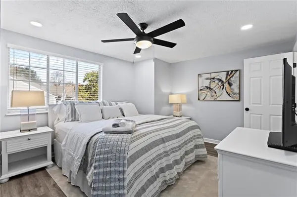 a bedroom with a bed and a table with a large window