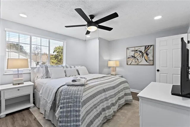 a bedroom with a bed and a table with a large window