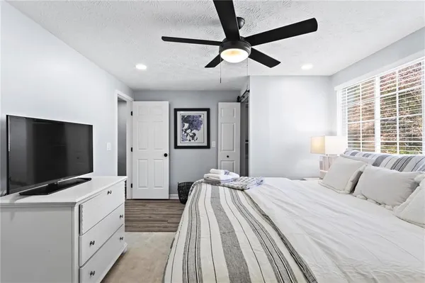 a bedroom with a bed and a flat tv screen on dresser
