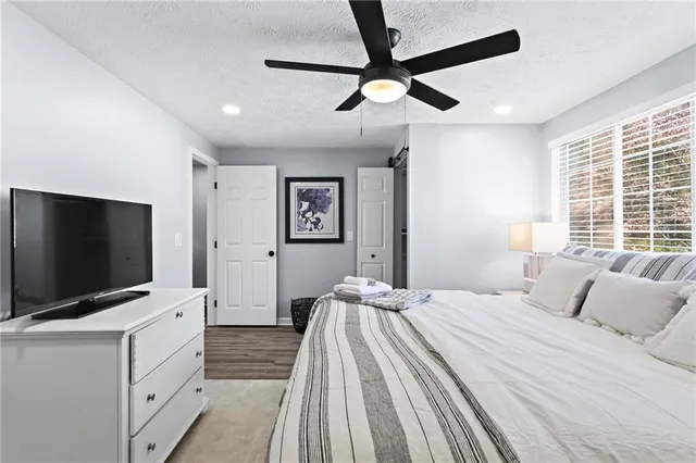 a bedroom with a bed and a flat tv screen on dresser