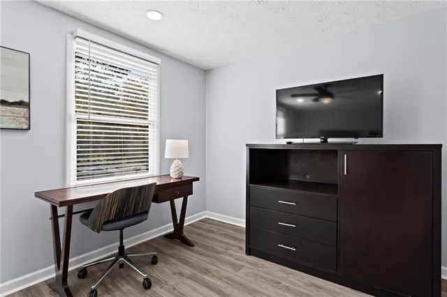 a view of a workspace with furniture and a flat screen tv