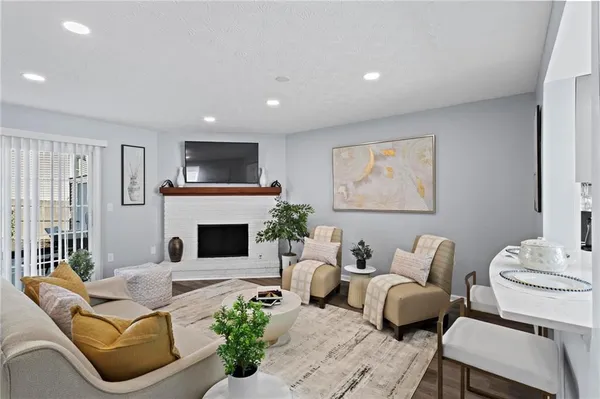 a living room with furniture a flat screen tv and a fireplace