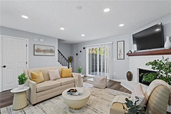 a living room with furniture a flat screen tv and a large window