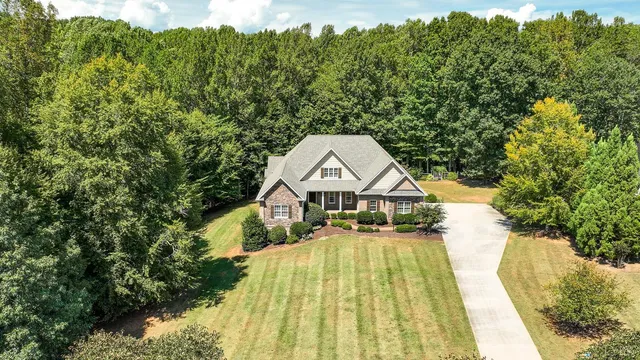 a view of house with a yard and potted plants