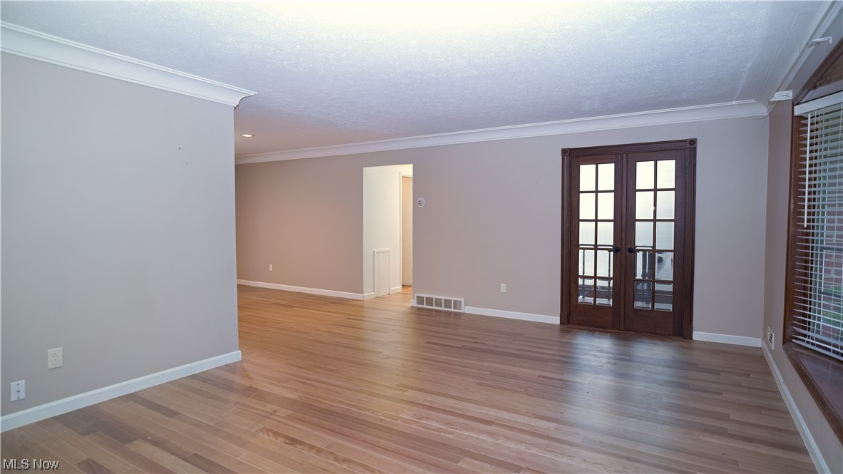 6676 Rochelle Boulevard Parma Heights, OH 44130 - Photo 5 of 21 Spare room with light hardwood / wood-style floors, french doors, and crown molding