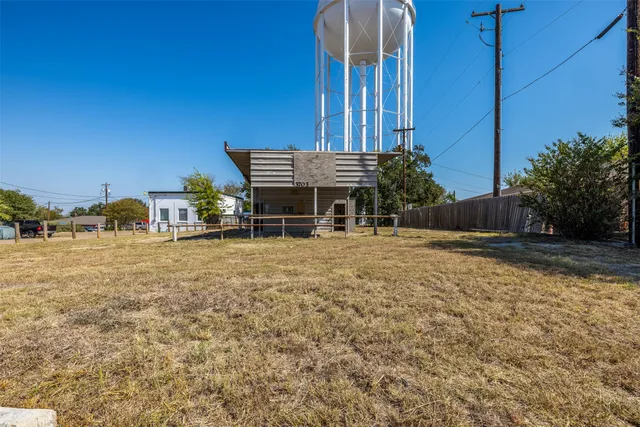 a view of a house with backyard and a tree
