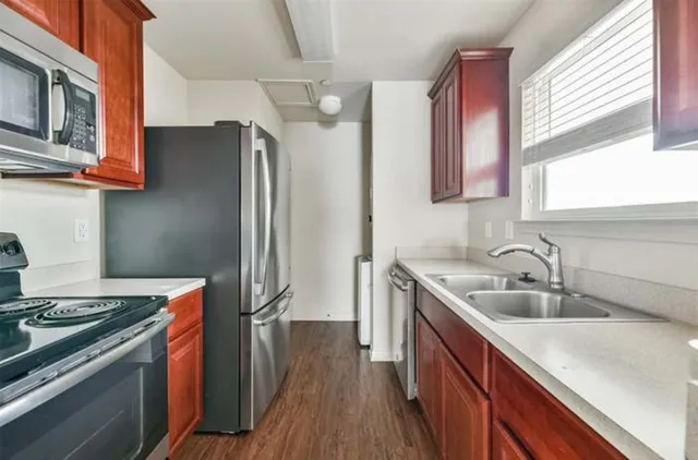 a kitchen with stainless steel appliances granite countertop a sink stove and refrigerator