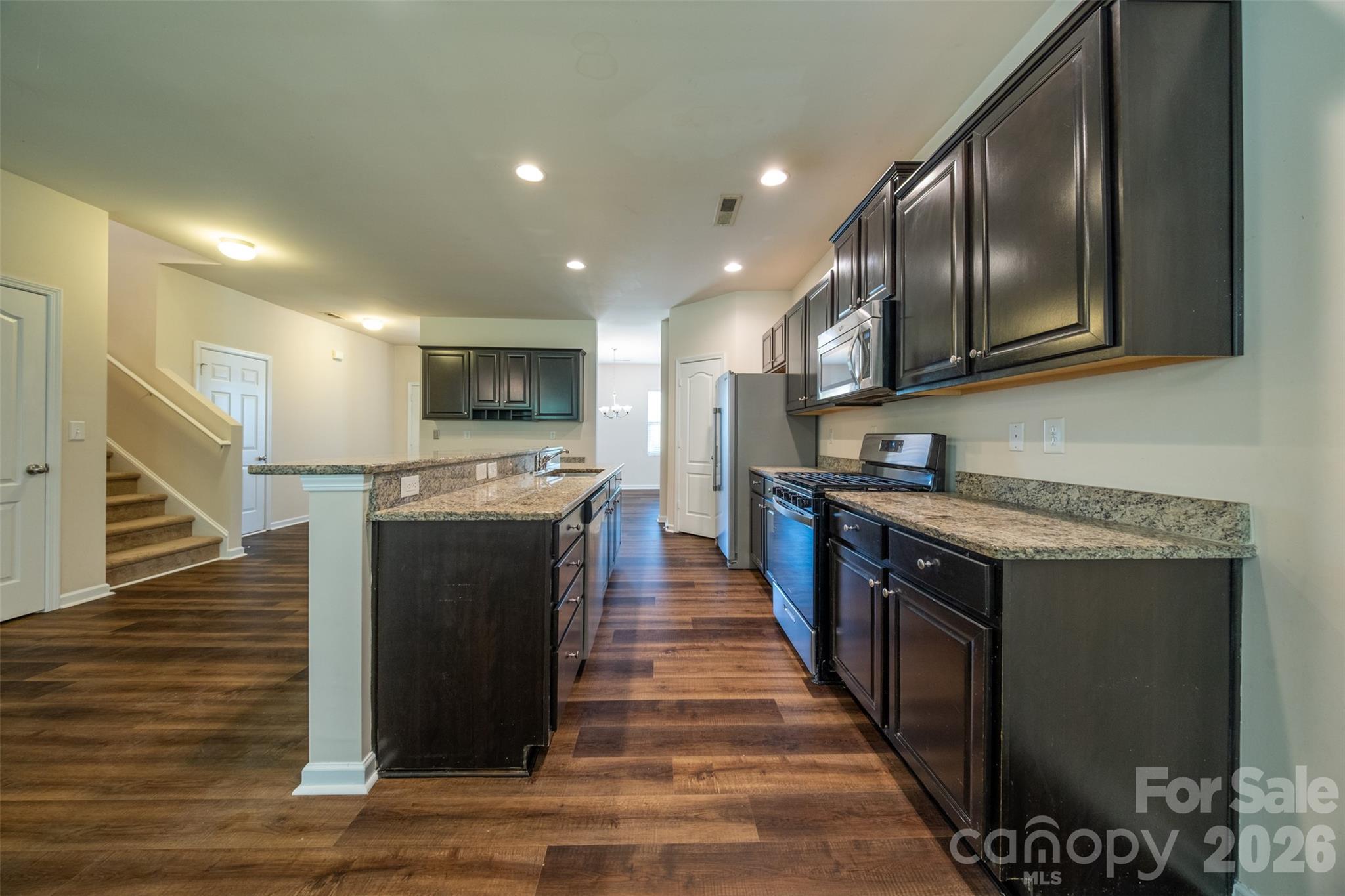 3006 Houndscroft Road Indian Trail, NC 28079 - Photo 12 of 39 a kitchen with stainless steel appliances granite countertop a stove a sink and a microwave