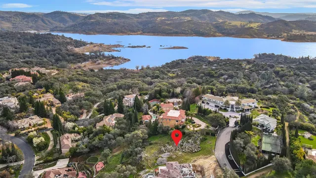an aerial view of a house with a yard and mountain view in back