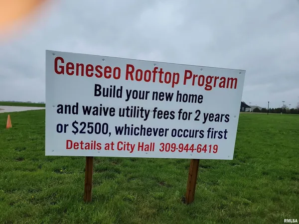 a sign is on the grass of the building