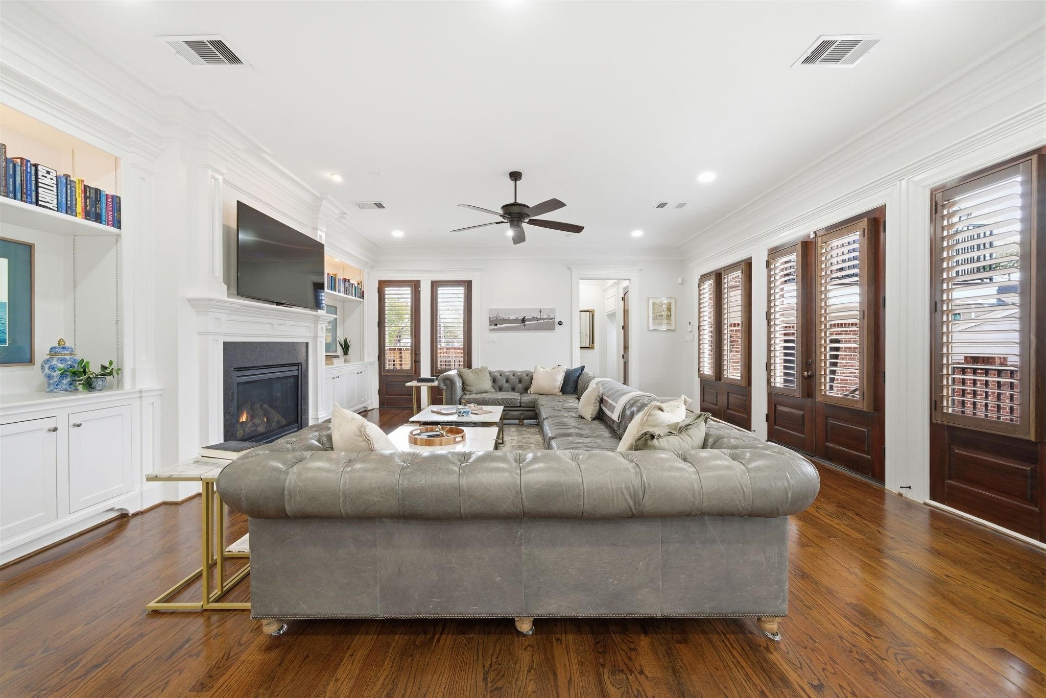 1418 Columbia Street Houston, TX 77008 - Photo 16 of 45 Soaring 10-foot ceilings, hardwood floors, detailed millwork, and custom fireplace built-ins anchor the space, while a rear hall provides access to the powder bath, three-car garage, and a privately situated guest suite.