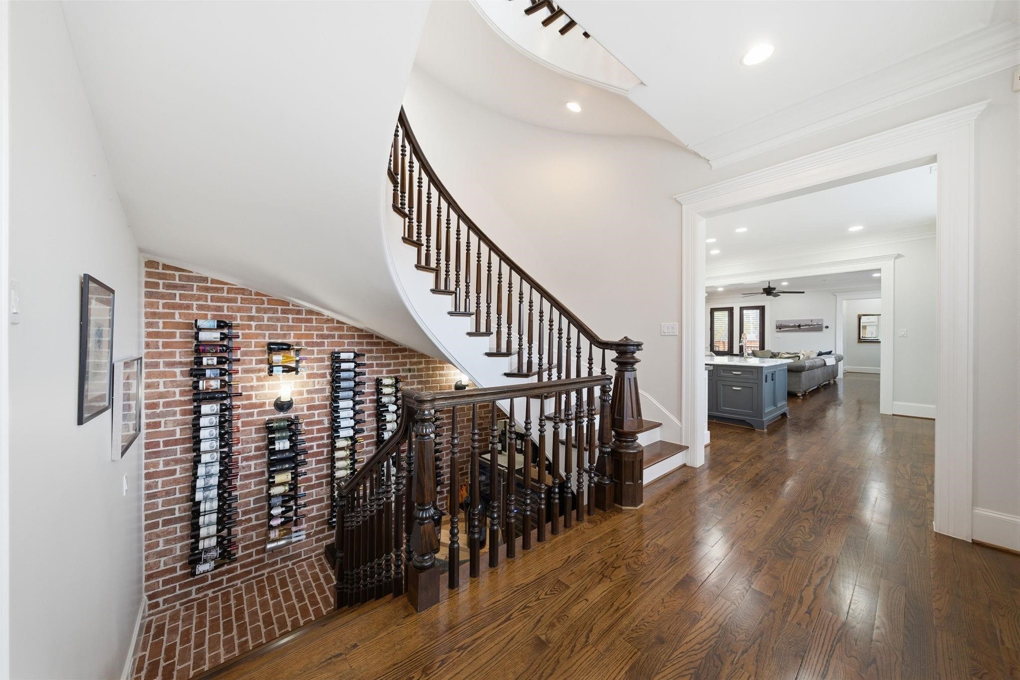 1418 Columbia Street Houston, TX 77008 - Photo 18 of 45 The sweeping curved staircase makes a statement at the center of the home, with the brick-accented wine grotto below. The open hallway connects the main living areas, reinforcing the home’s thoughtful flow.