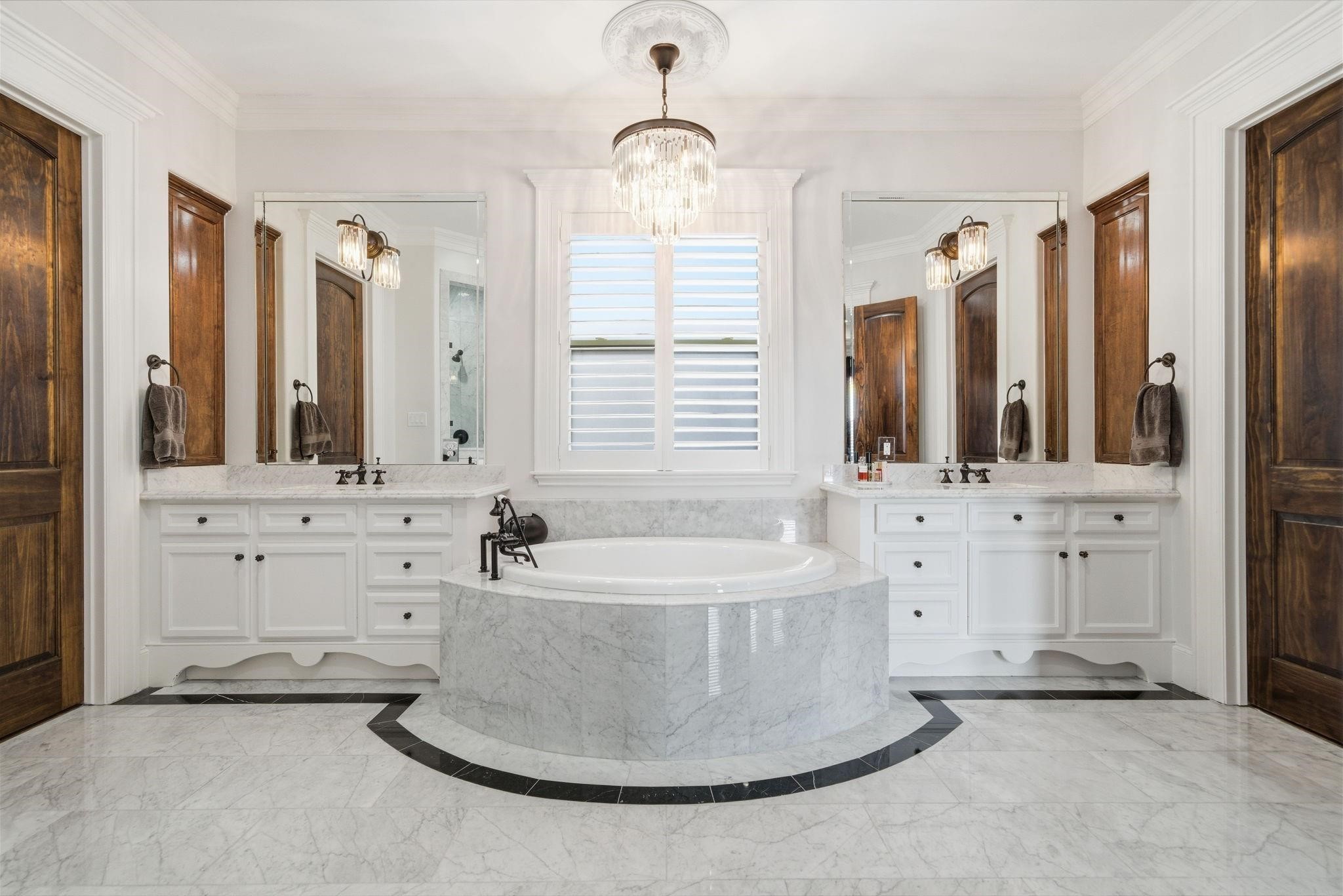 1418 Columbia Street Houston, TX 77008 - Photo 23 of 45 Inspired by the Ritz Carlton, the primary bath makes a statement with marble floors accented by black marble detailing, a dramatic soaking tub centerpiece, dual vanities and elegant lighting that elevates the space.