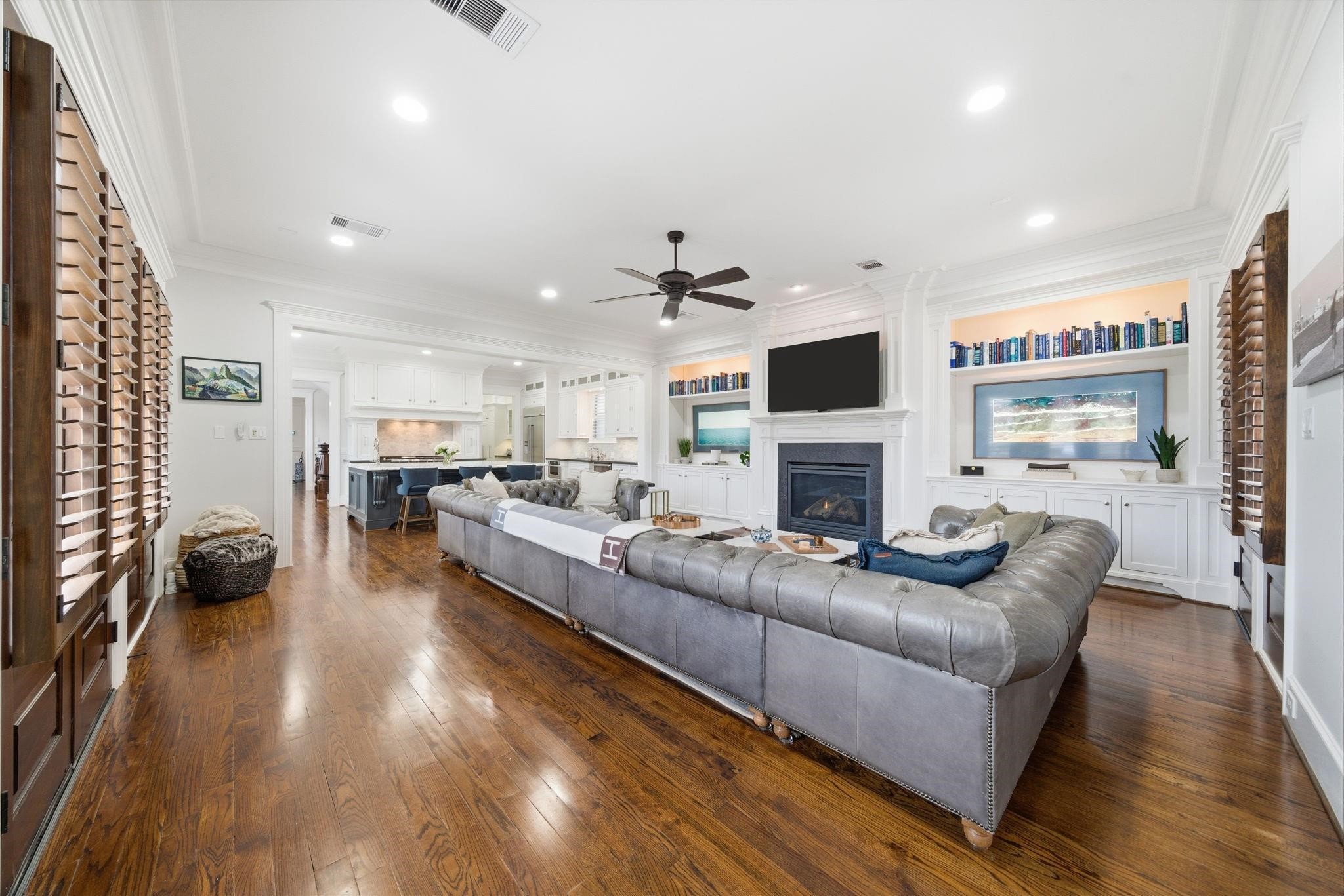 1418 Columbia Street Houston, TX 77008 - Photo 4 of 45 Impressive living room with 10-foot ceilings, hardwood floors, custom built-ins, and a fireplace focal point, flowing seamlessly into the kitchen for effortless living and entertaining.