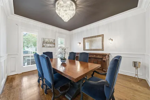 a kitchen with stainless steel appliances granite countertop a table chairs sink and cabinets