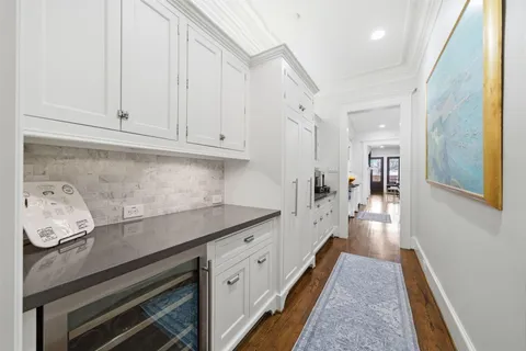 a living room with furniture kitchen view and a large window