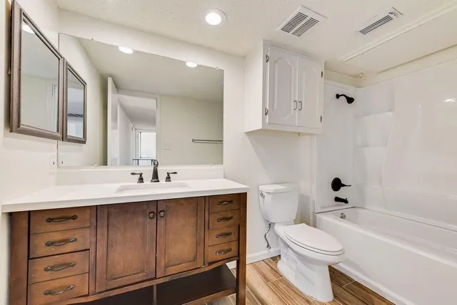 a bathroom with a sink a toilet a mirror and vanity