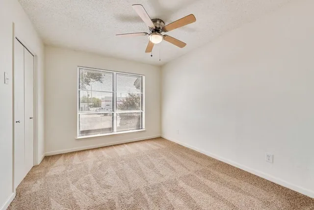 an empty room with fan and windows