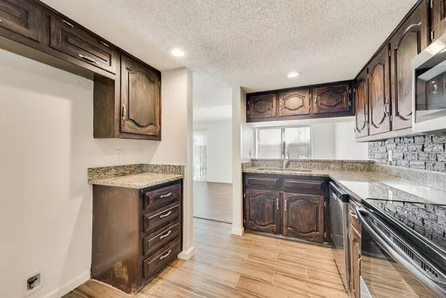 a kitchen with stainless steel appliances granite countertop a stove and a sink