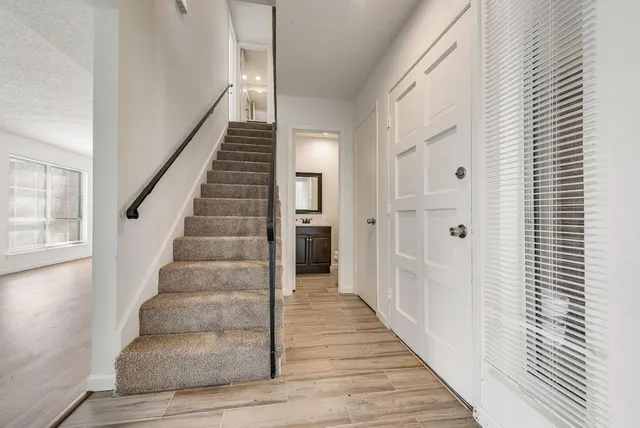 a view of a hallway with wooden floor and entryway