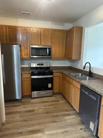 a kitchen with granite countertop a refrigerator stove and microwave