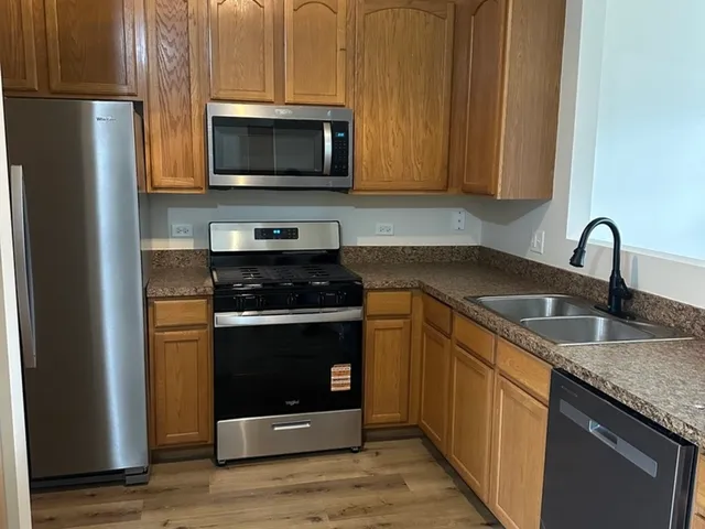 a kitchen with stainless steel appliances granite countertop a stove microwave and refrigerator