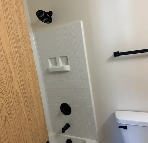 a bathroom with a granite countertop sink toilet and mirror