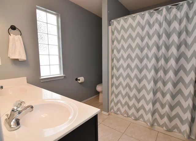 a bathroom with a sink a toilet and a window