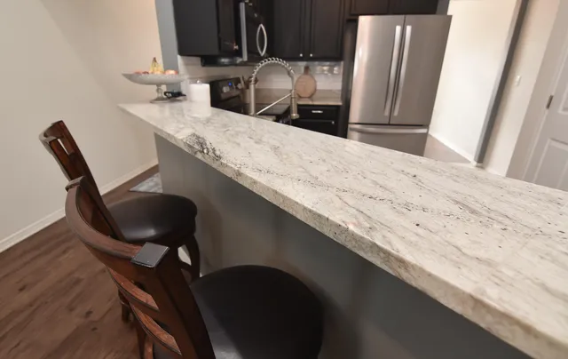 a bathroom with a granite countertop sink a mirror and cabinets