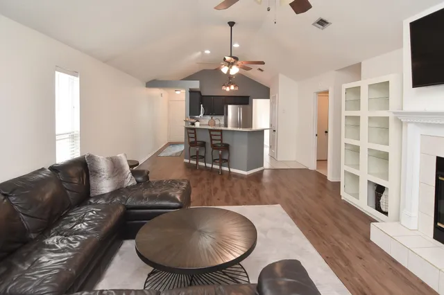 a living room with furniture dining table a rug and a chandelier