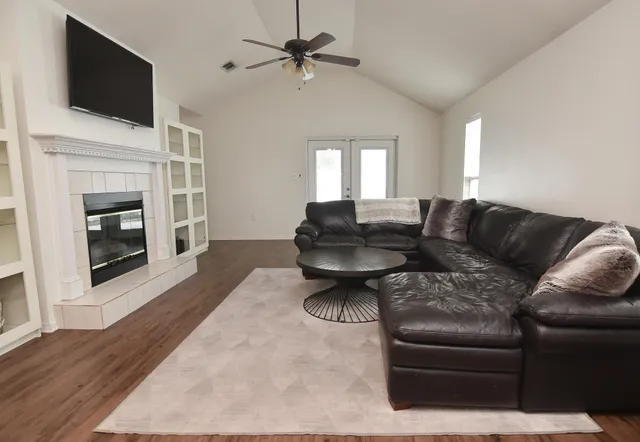 a living room with furniture a fireplace and a flat screen tv