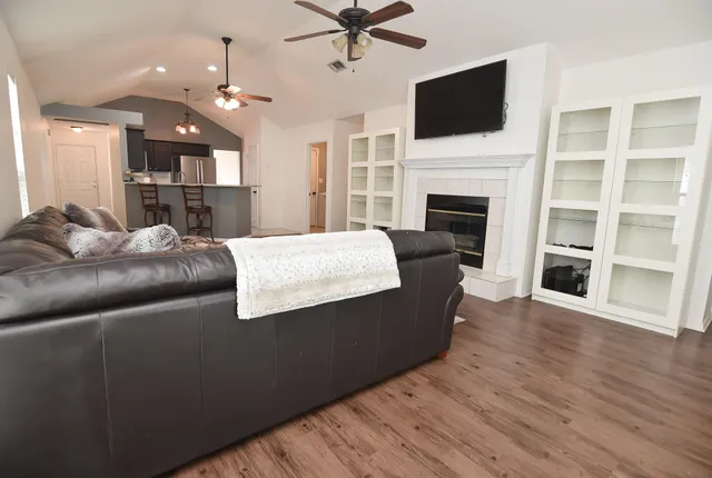 a living room with furniture a flat screen tv and a fireplace