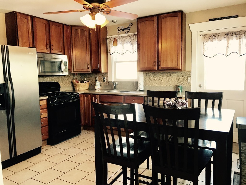 92 Howland Road Fairhaven, MA 02719 - Photo 6 of 27 a kitchen with granite countertop a dining table chairs stainless steel appliances and cabinets