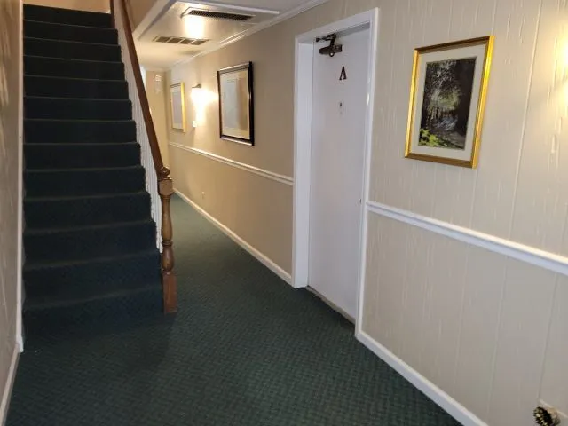 a view of staircase with wooden floor and white walls
