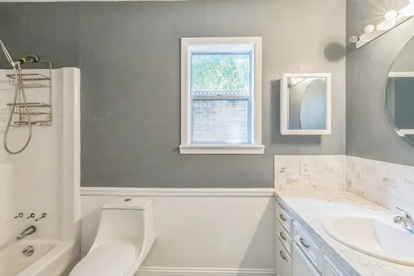 a bathroom with a sink vanity tub and a toilet