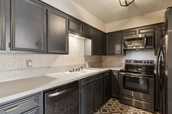 a kitchen with a sink and stainless steel appliances