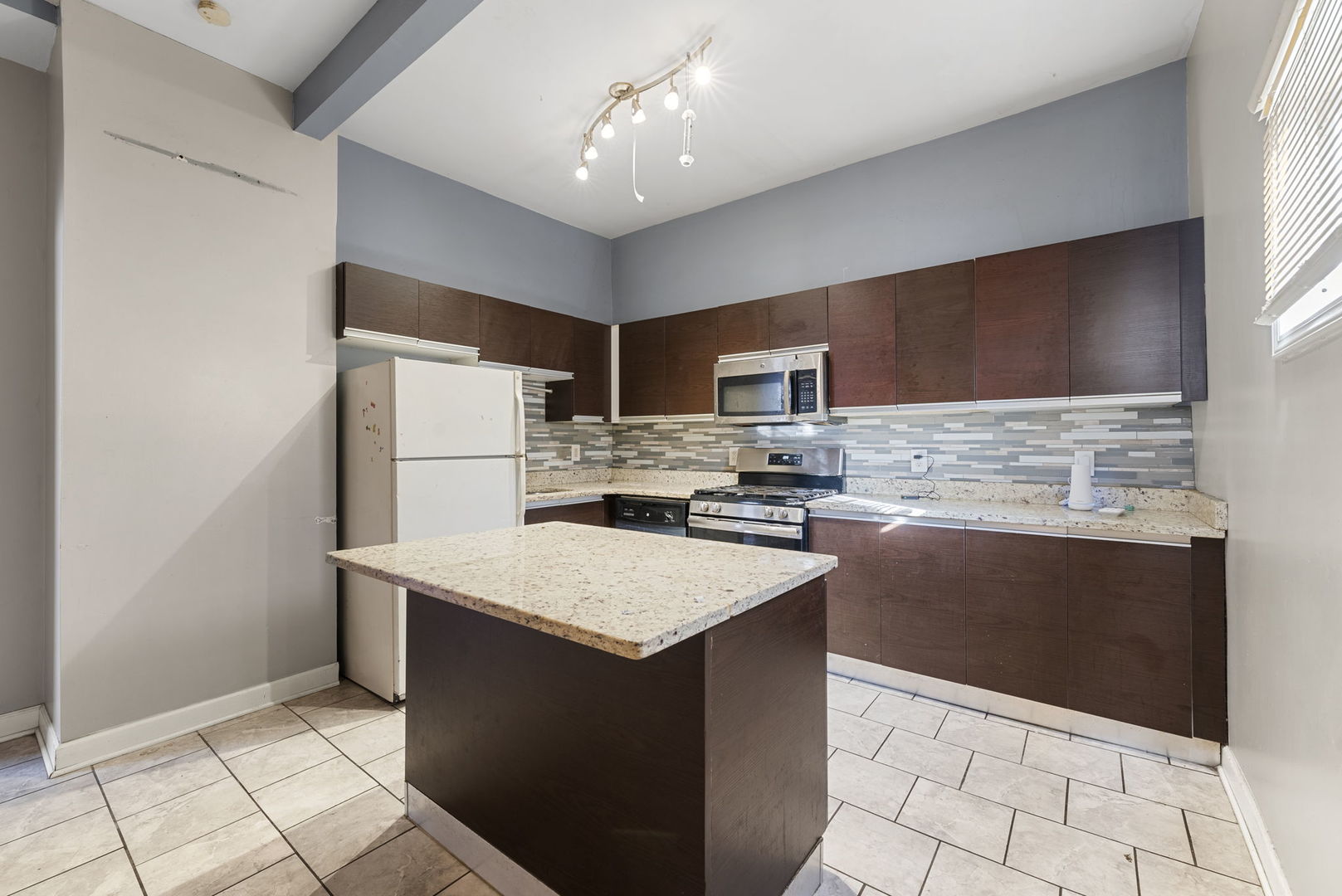 321 West 59th Place Chicago, IL 60621 - Photo 5 of 23 a kitchen with stainless steel appliances a refrigerator sink and microwave