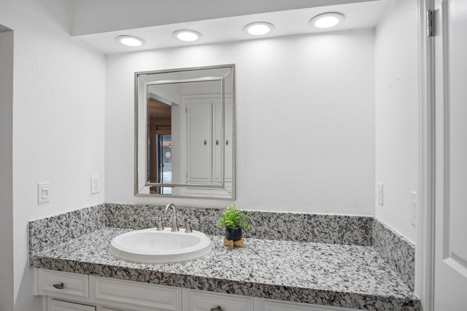 10401 Golf Link Road Turlock, CA 95380 - Photo 22 of 63 a bathroom with a granite countertop sink and a mirror