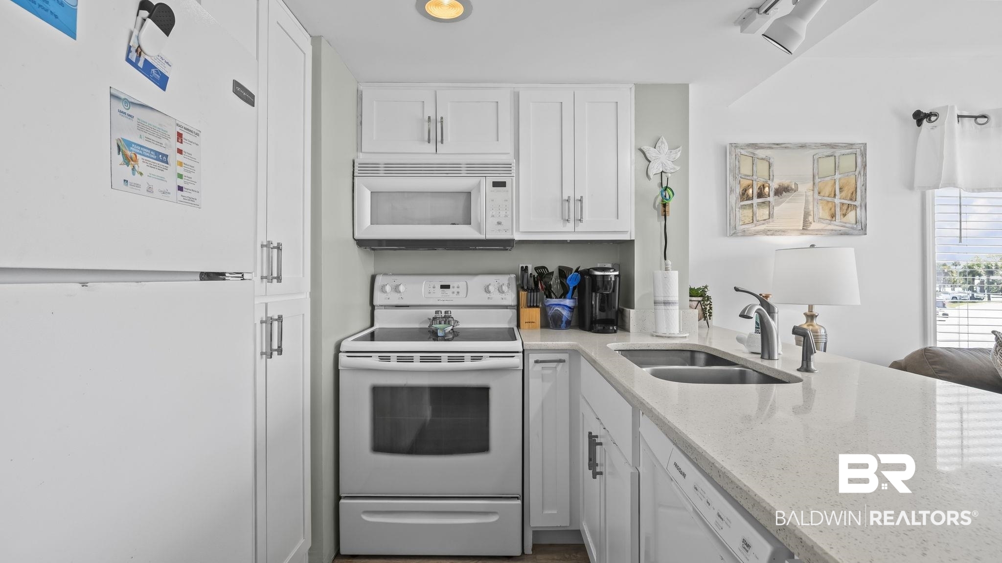 497 Plantation Road, Unit 1247 Gulf Shores, AL 36542 - Photo 7 of 29 Kitchen featuring white appliances, light stone countertops, and white cabinets