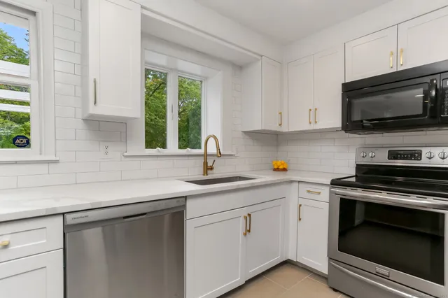 a kitchen with white cabinets and a stove top oven