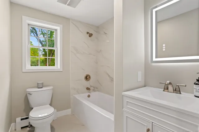 a bathroom with a toilet a sink and bathtub