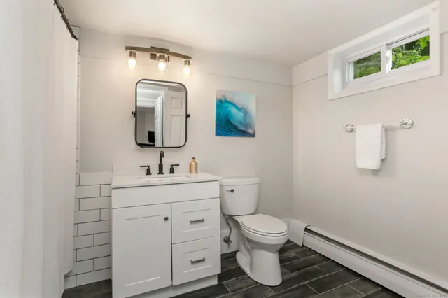 a bathroom with a toilet sink and mirror
