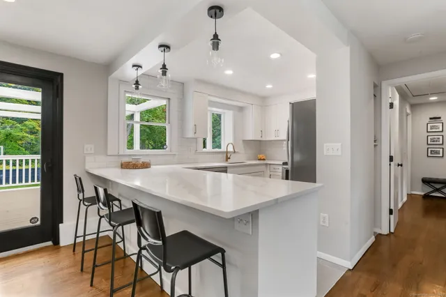 a kitchen with kitchen island a sink dining table and chairs