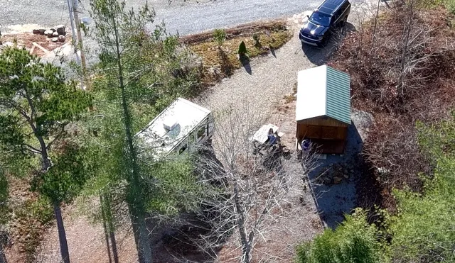 a view of a house with a yard and large trees