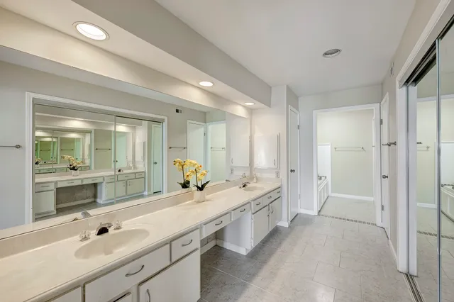 a spacious bathroom with a double vanity sink mirror and double