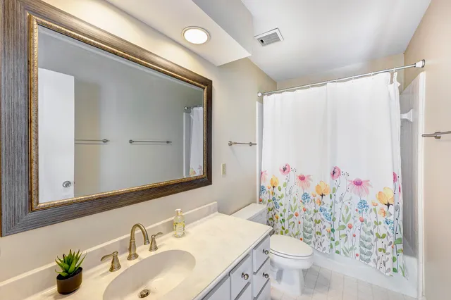 a bathroom with a sink vanity mirror and toilet