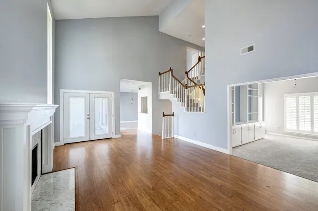 a view of empty room with fireplace and wooden floor